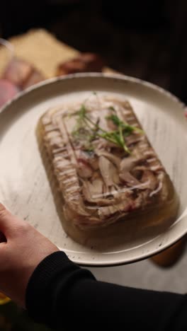 woman holding a plate of jellied meat