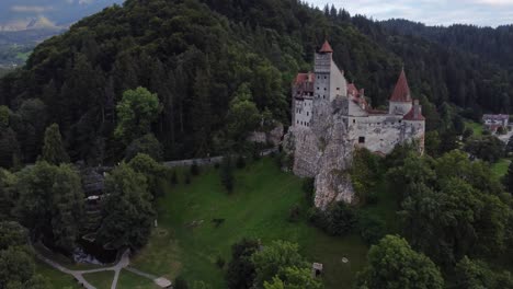 Slow-orbiting-aerial-shot-of-Bran-castle-in-Brasov,-Romania-on-overcast-day