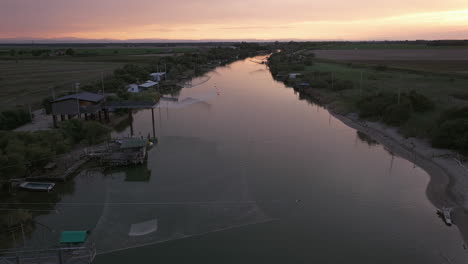 slow-motion view of fishing huts on shores of estuary at sunset,italian fishing machine, called "trabucco",lido di dante, ravenna near comacchio valley