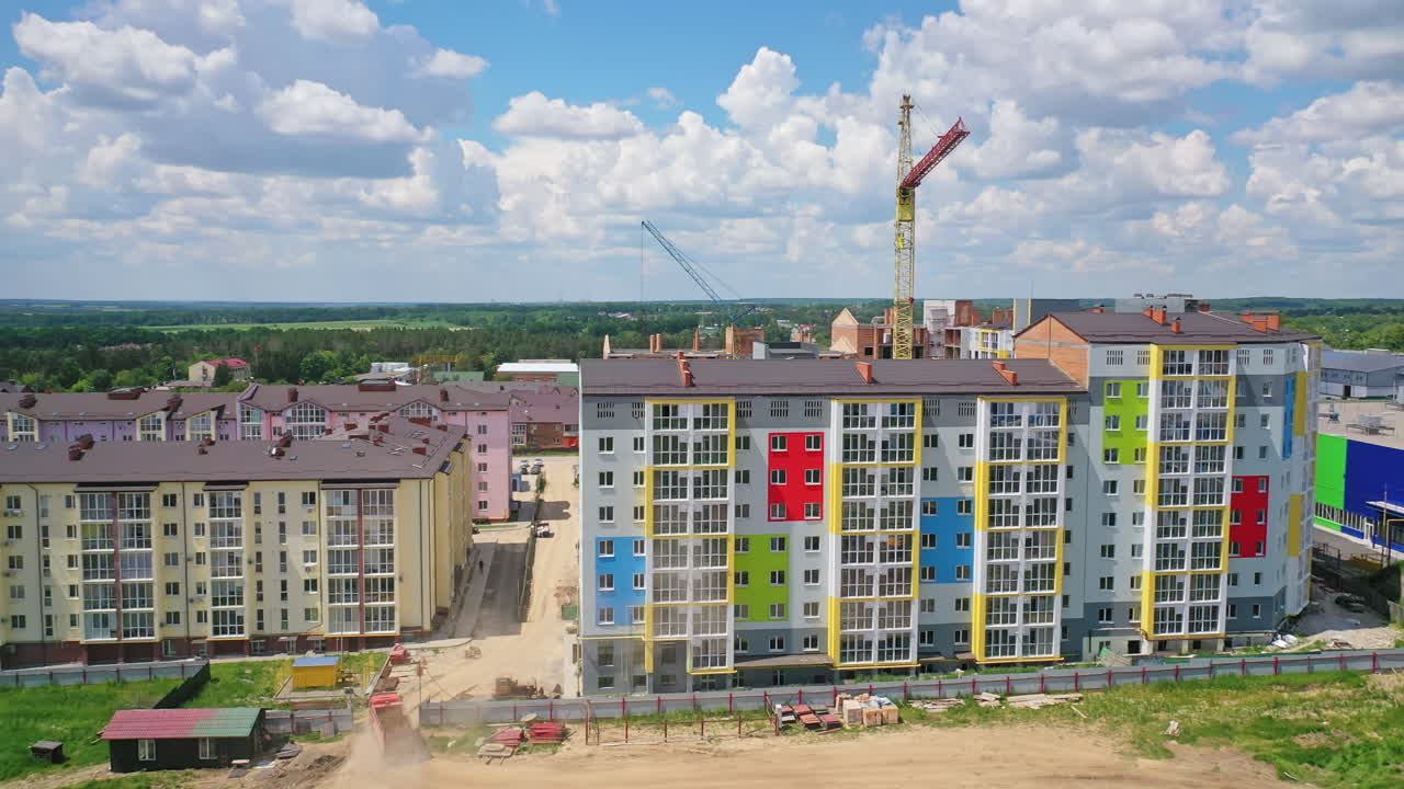 New high rise building with colorful exterior. Construction site with modern apartments in the city. Building of a new urban district.