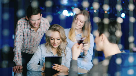 A-Group-Of-Cheerful-Young-People-Look-At-The-Tablet-Screen