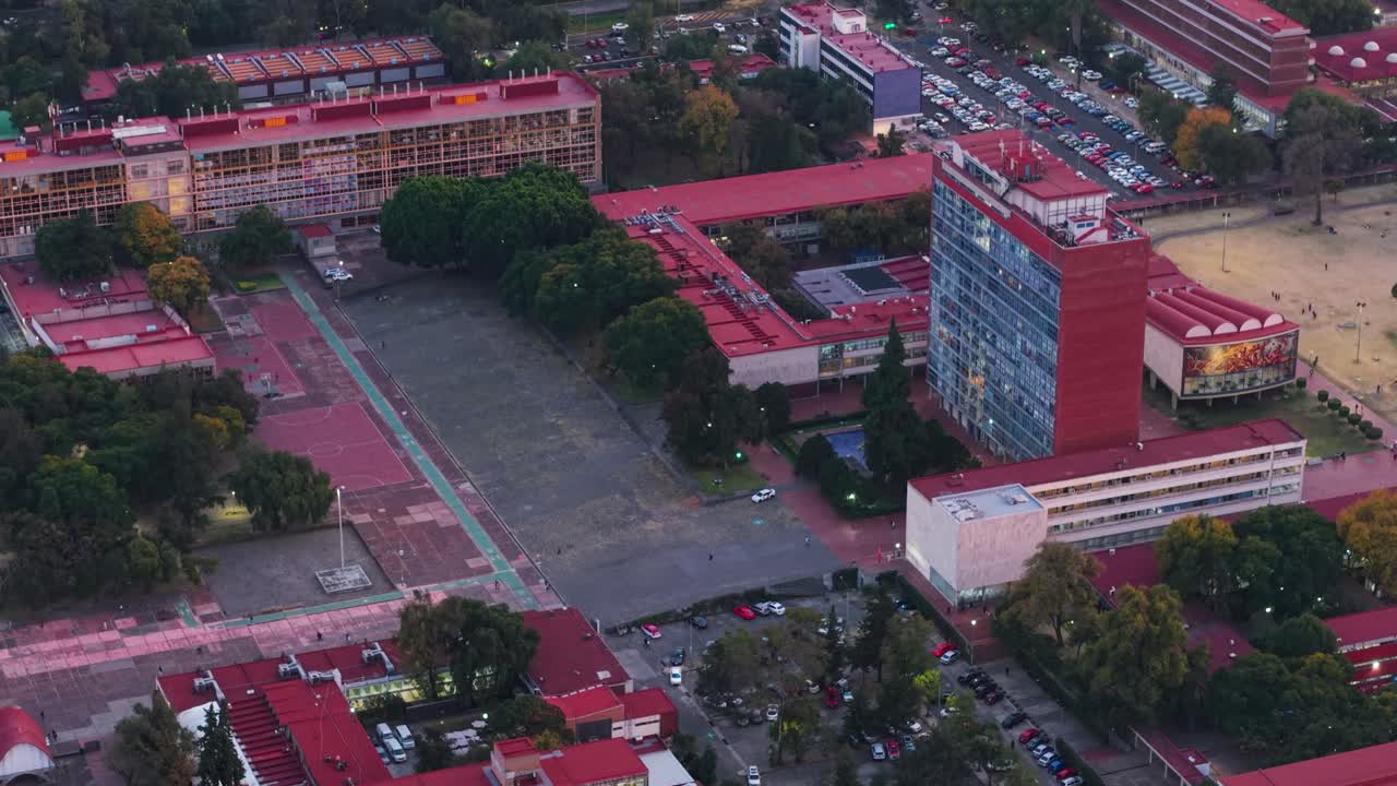 Sunset over the university campus, featuring parking lots and walkways, filmed by drone