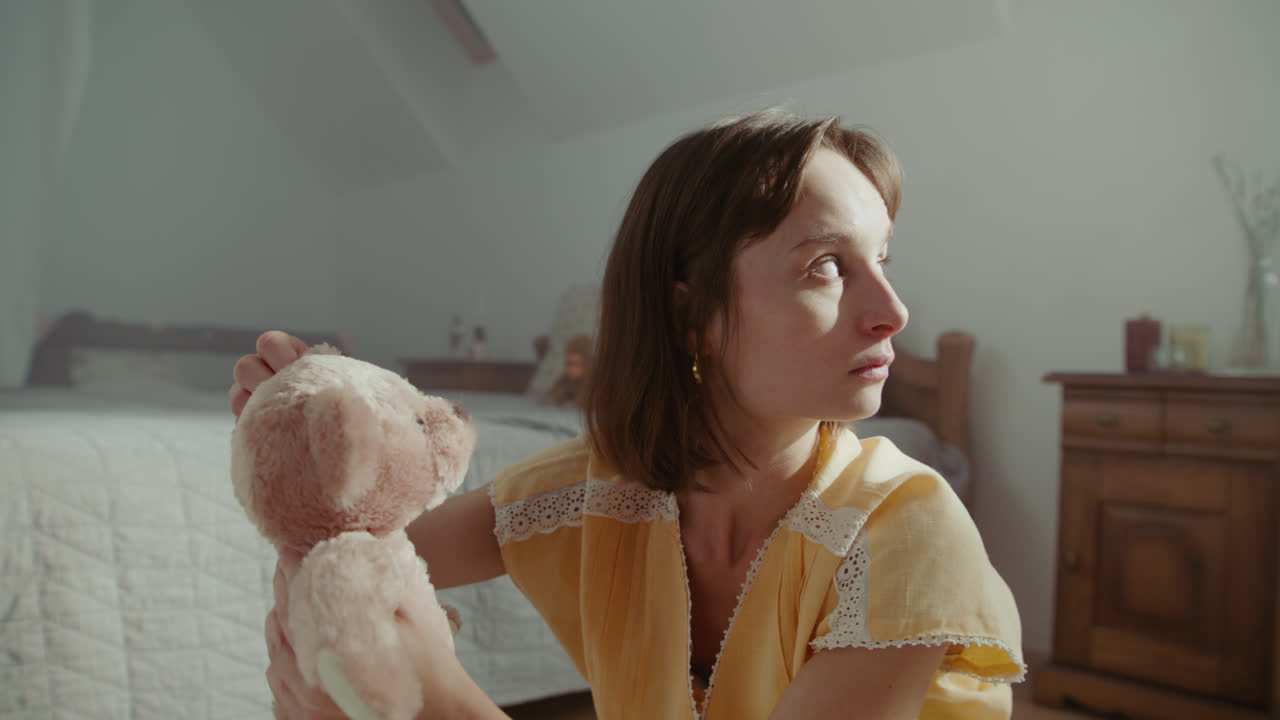 A girl playing with dolls in her room