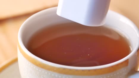 adding sugar to tea