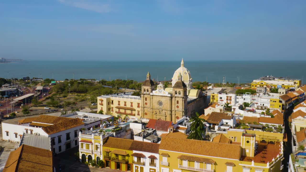 Drone sobrevoa edifícios coloniais coloridos em direção a uma igreja com cúpula em Cartagena, Colômbia