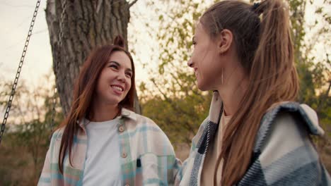 Close-up-shooting:-Two-girlfriends-in-checkered-shirts-hug-and-look-into-the-distance.-Rest-in-the-country-house