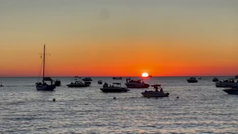 Lebhafter-Strand-Auf-Ibiza-Mit-Türkisfarbenem-Wasser-Und-Menschen,-Die-Einen-Sonnigen-Tag-Genießen