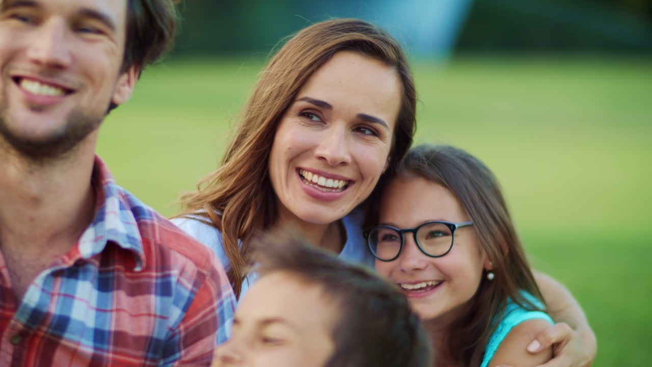 Happy kids and parents using mobile phone for video call outdoors