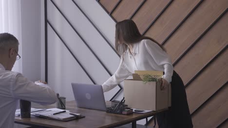 a woman is collecting her things in an office. she is quitting her job. she is low-spirited.