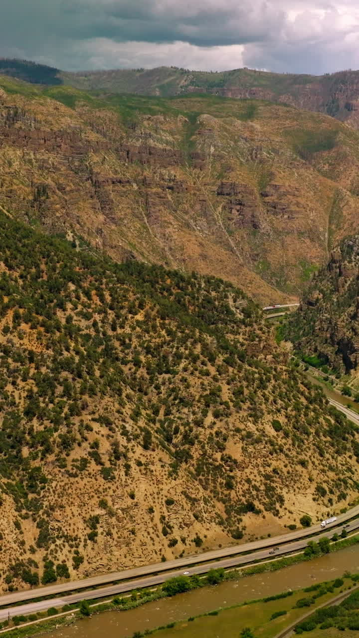 Excellent panorama of beautiful mountains in Colorado, USA. Highways and narrow river twirling between the mountains. View from above. Vertical video