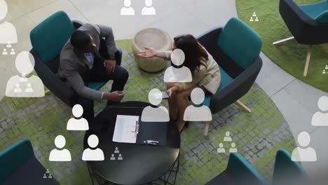 animation of user icon floating over diverse male and female business colleagues talking in office