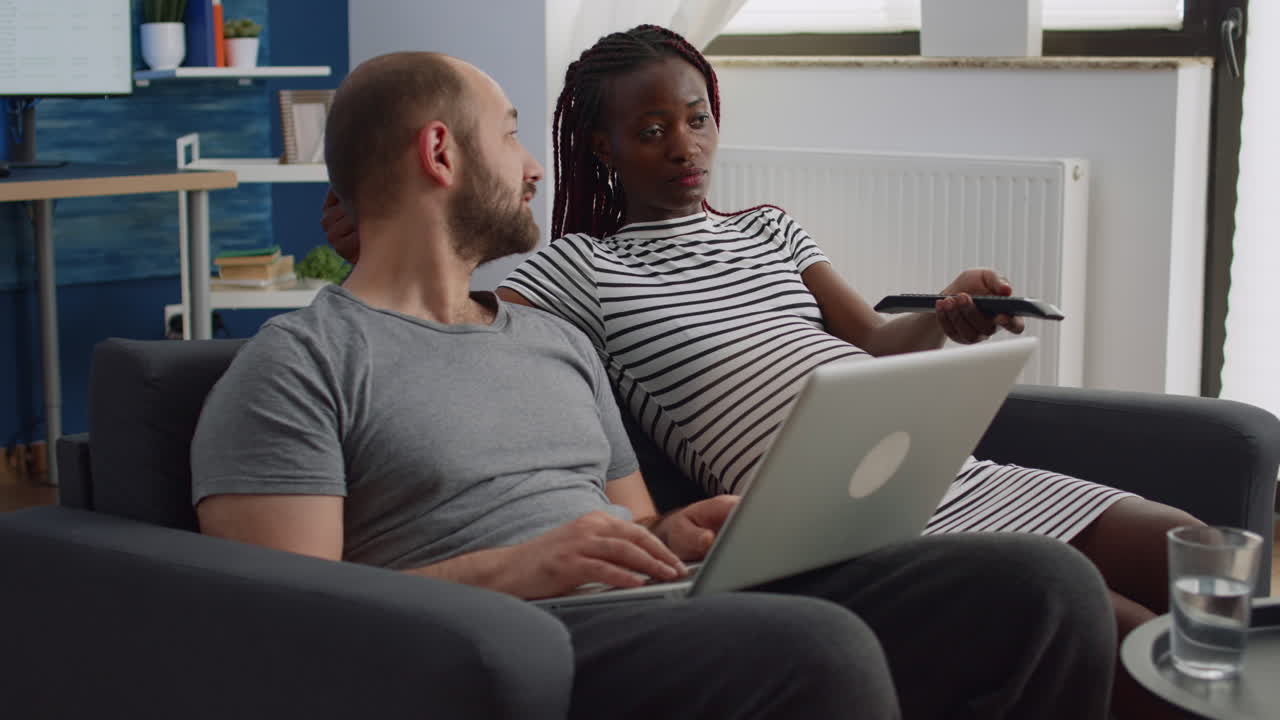 Interracial couple with pregnancy relaxing together at home