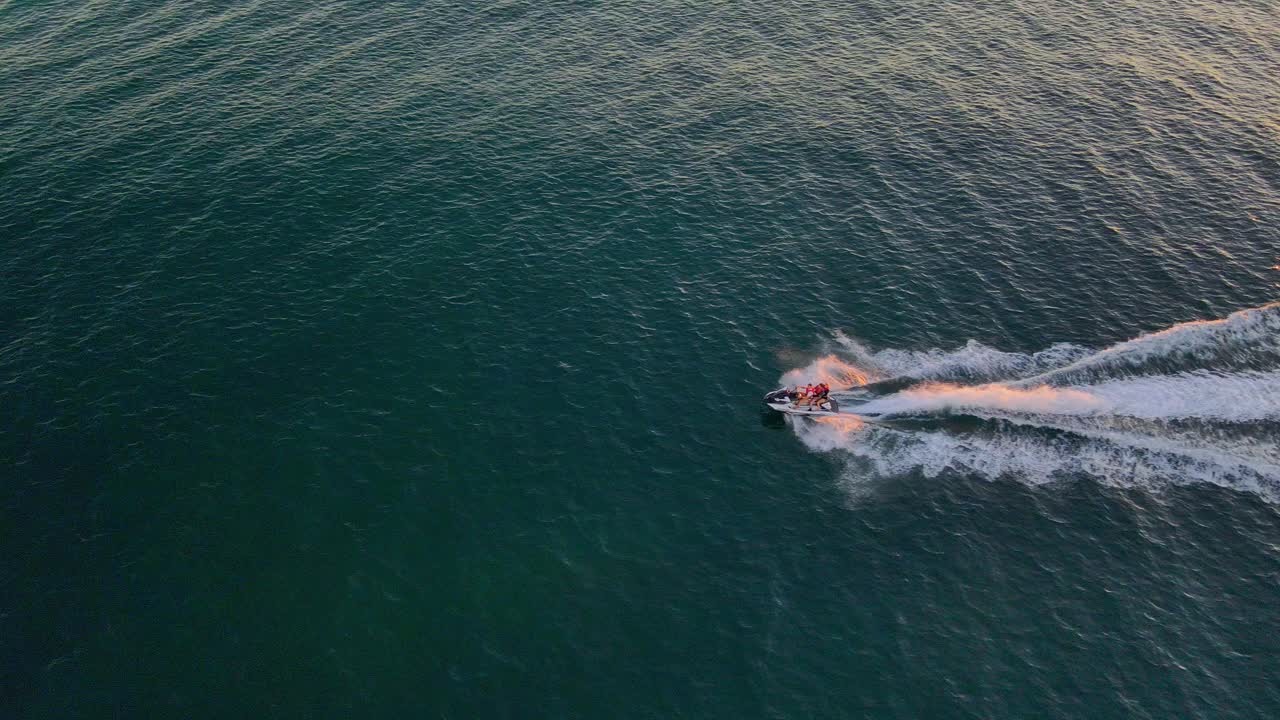 Turysta na skuterze wodnym – jazda na skuterze wodnym przy plaży o wschodzie słońca w QLD, Australia.