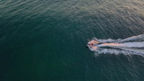 tourist rides on jet ski - jet skiing by the beach at sunrise in qld, australia