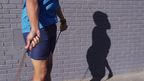 도시에서 운동하는 적합한 아프리카계 미국인 남성, 거리에서 스키핑 로프와 함께 점프