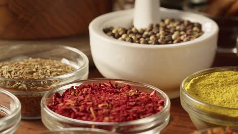 various spices in glass bowls close-up. middle eastern and arabian culture. seasoning and flavors. pepper, coriander, vanilla, turmeric, paprika, cumin. different kinds of dry herbs for cooking.