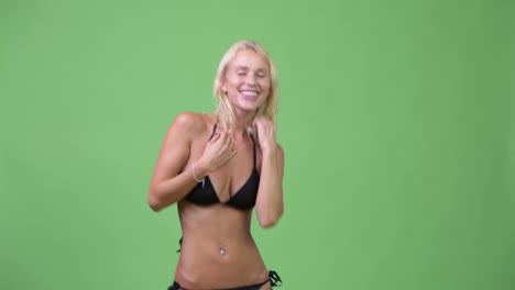 happy young beautiful blonde woman dancing in bikini