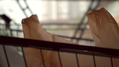 shopping cart outside rainy day mall depicting current use of plastic bags