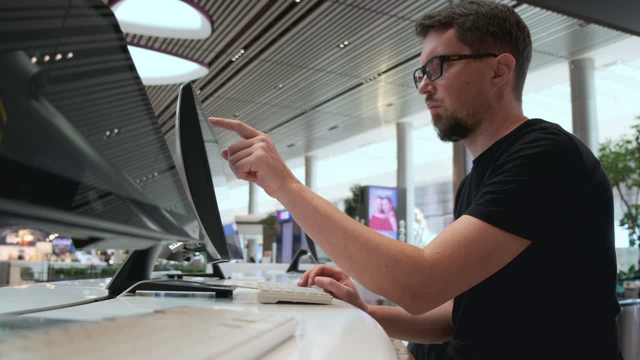 Man working on a computer in an airport terminal