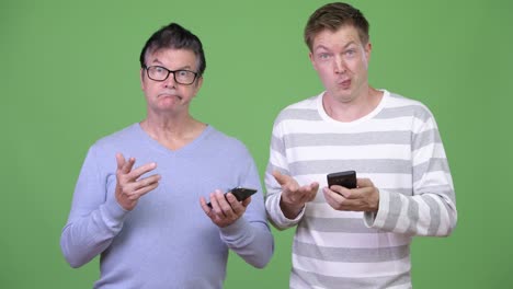 senior handsome man and young handsome man using phone together