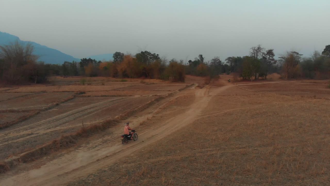 Moto a Thakhek su strada polverosa al tramonto, Laos