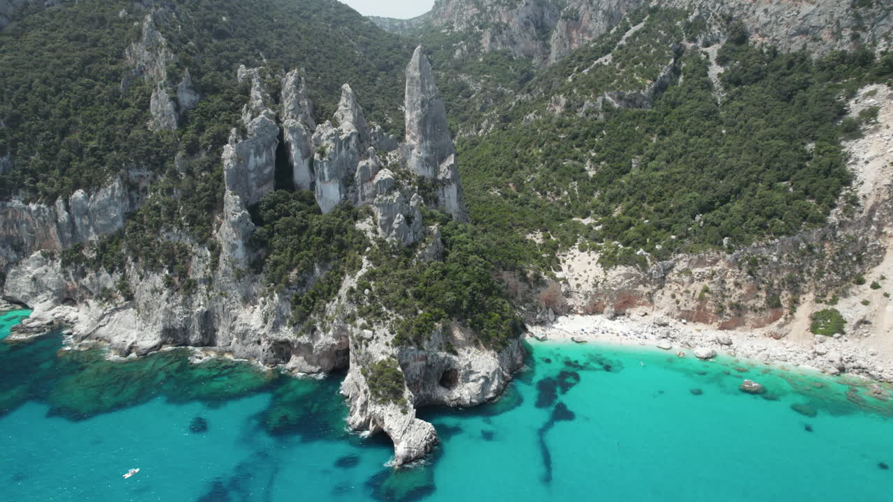 Aerial drone video of tropical paradise turquoise beach and sea cliffs in the mediterranean, Costa Azzurra, Sardinia