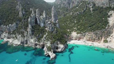 aerial drone video of tropical paradise turquoise beach and sea cliffs in the mediterranean, costa azzurra, sardinia