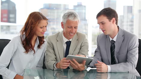 Smiling-work-team-using-a-tablet-computer