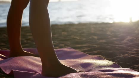 Woman-performing-stretching-exercise-on-the-beach