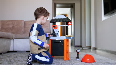 a young boy playing with a toy workbench