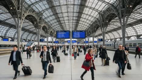 a bustling train station scene capturing the movement of travelers with luggage beneath a grand, architecturally stunning canopy of glass and steel