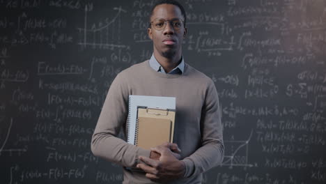 portrait of a teacher in front of a chalkboard