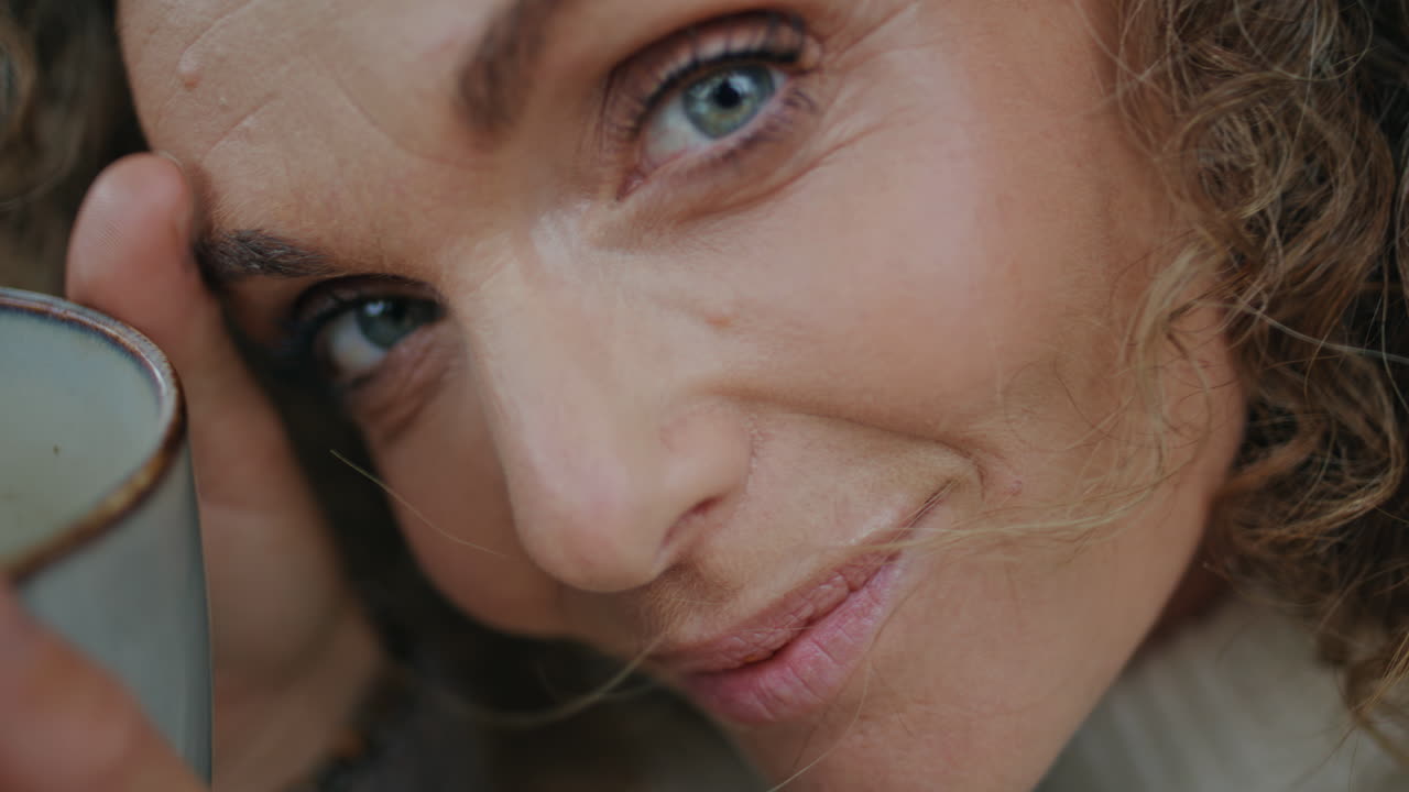 retrato de una mujer bebiendo té sentada en la naturaleza sola. mujer feliz mirando la cámara