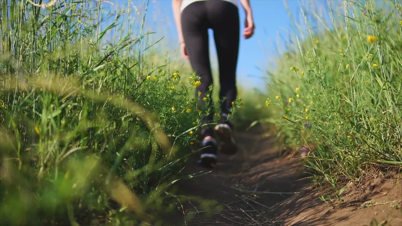 Woman Walking Through a Grassy Field