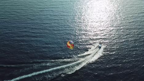 Aerial-shot-of-a-boat-draging-a-parachute-in-the-sea