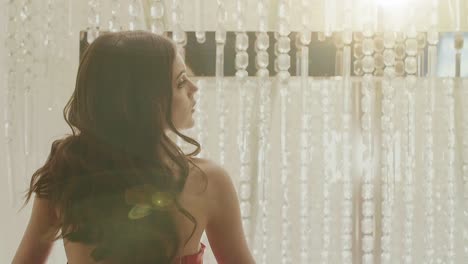 woman in red dress by chandelier