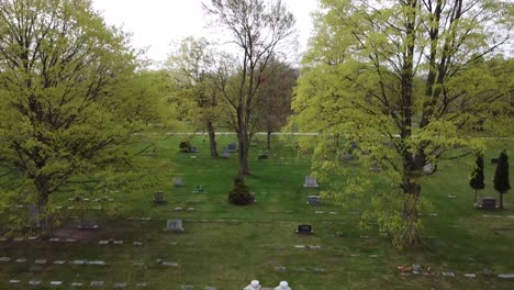 cemetery graveyard burial site wide shot green foliage trees grave site grave stones 4k