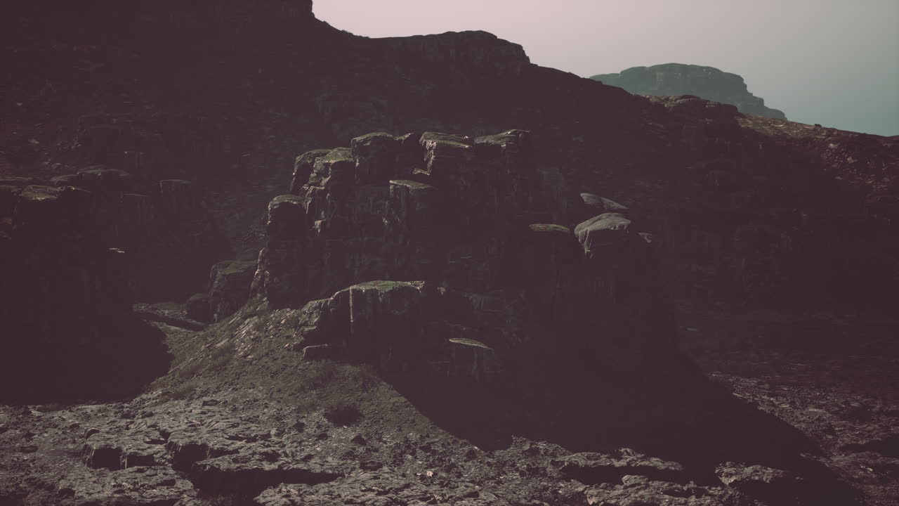 una montaña rocosa con algunos animales en ella