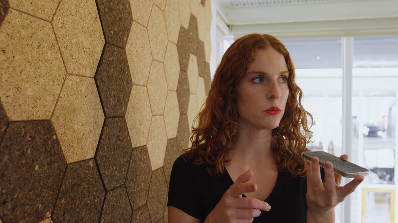 사무실 4k에서 휴대 전화로 이야기하는 사업가