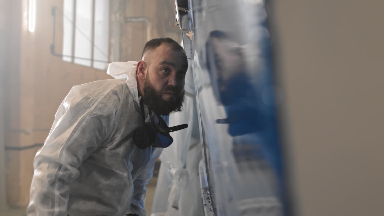 Man Wearing Protective Suit Wiping Surface