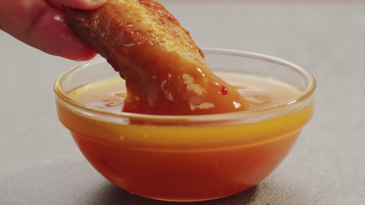 Alette di pollo immerse nella salsa