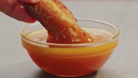 chicken wings dipping in sauce