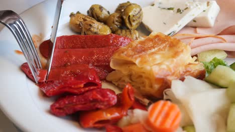 Woman-slicing-salami-sausage-on-a-plate-,