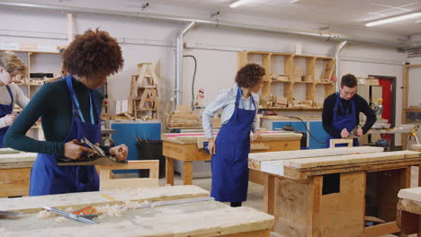 tutors with carpentry students in workshop studying for apprenticeship at college