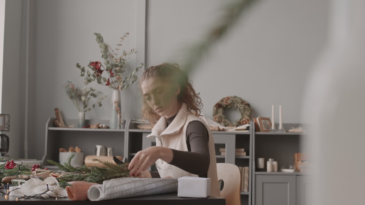 женщина режет ветви рождественской елки