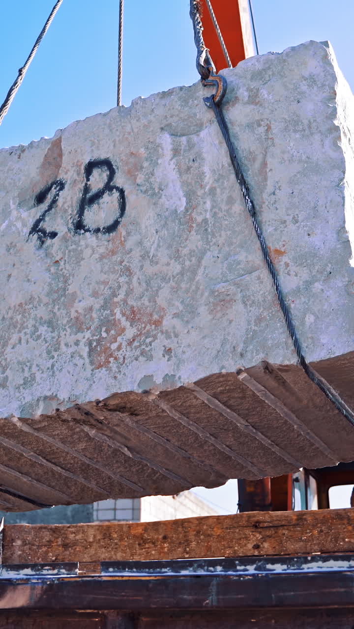 Blocks of marble in quarry. Industrial view of crane loading marble Vertical video