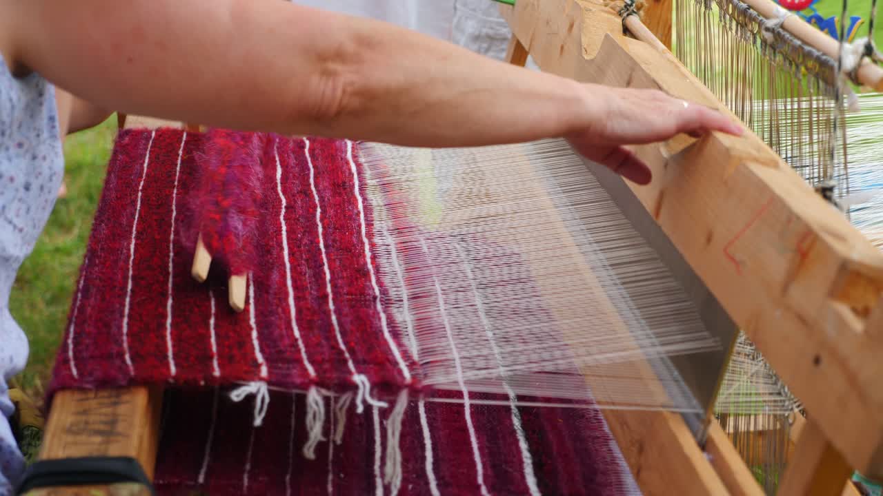 un hilandero hace tela con un niño, cámara lenta de 50 fps