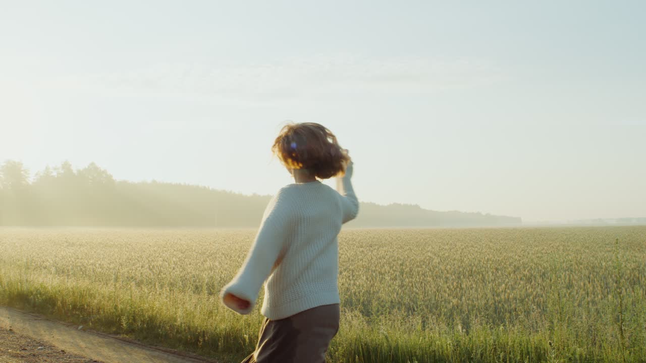 mujer disfrutando de un hermoso amanecer en un campo de trigo