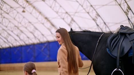 woman and child with a horse at a riding stable