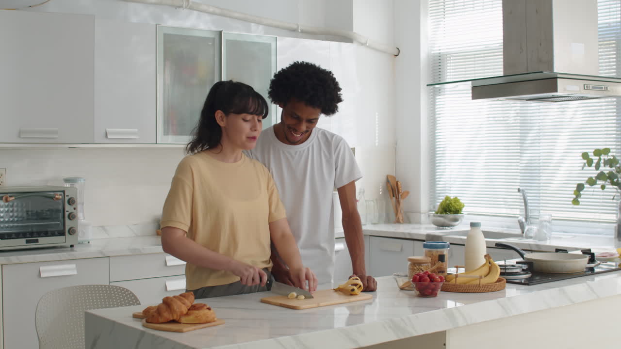 Coppia birazziale che prepara la colazione insieme in cucina